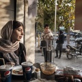 Maryam, 22, during a lunch break with typical iranian food (tadig rise and halim budenjun) and Pepsi Cola. Tehran, Iran. November 2014.