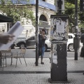 Two Colombian men are attacking the papelitos on the street. The papelitos are like post-it, glued on poles, bins or on the walls of the streets, which with a cartoon drawing or the image of a half-naked woman, invite to call the number overwritten, describing the " goods "available: new, younger than 21 years, in promotion or high level. Buenos Aires, Argentina. January 2017.
